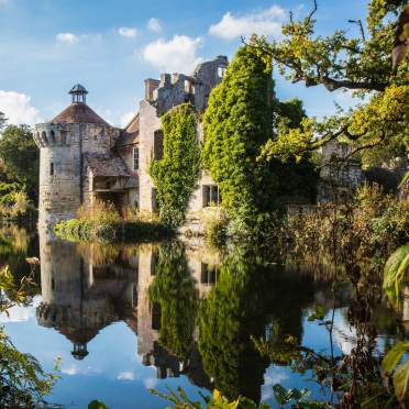 Scotney Castle with a pond on a summer day