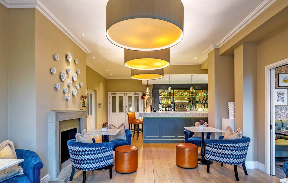Bistro with blue armchairs, caramel leather stools and beige walls
