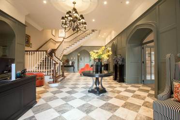 Reception area with chess tiles on the floor, chandelier and luxury decor