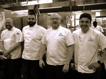 Chefs Micheal Houlden, Gurpreet Singh, Kevin Connor, Alistaire Eckles Four chefs in white uniforms stand in a commercial kitchen, smiling.